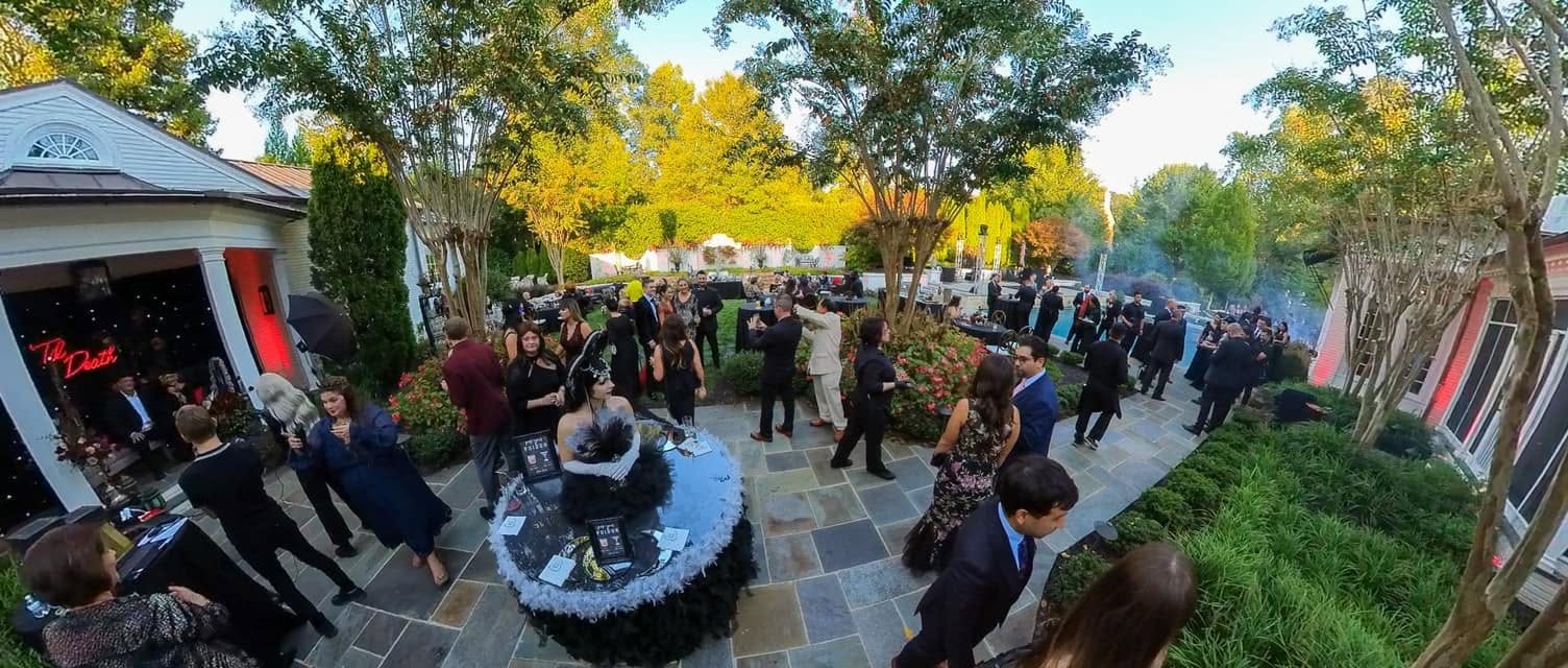 Living Table performer surrounded by guests in an outdoor event environment